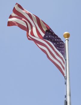 American flag waving in blue sky