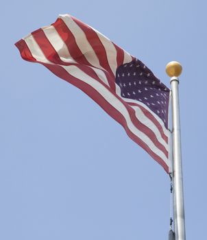 American flag waving in blue sky