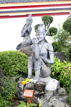 Thai Buddha stone stateue with flower garmet