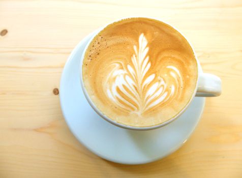 Latte art coffee on wooden table