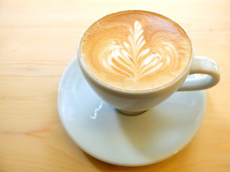 Latte art coffee on wooden table