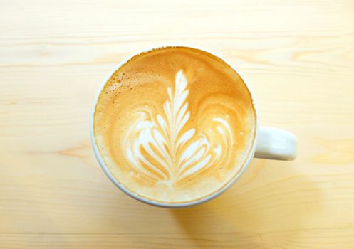 Latte art coffee on wooden table