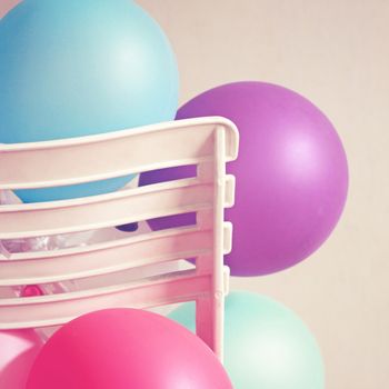 Colorful balloons on chair with retro filter effect