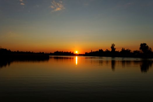 Colorful sunset over tranquil water surface.