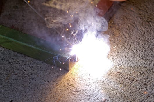 Iron welding with bright light and smoke at manufacturing