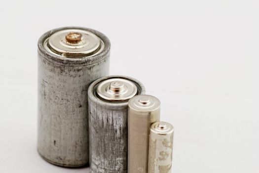 Old grey batteries on white background (aa, aaa, b, c)