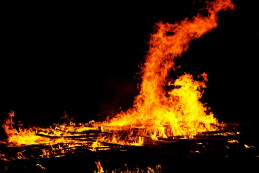 red flames of huge bonfire or campfire as black backgorund