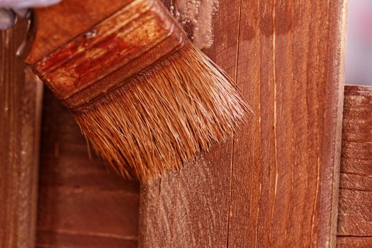 planks fence dyeing with brown paint and brush