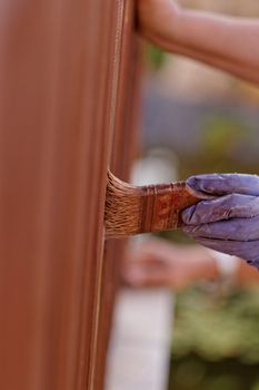 planks fence dyeing with brown paint and brush