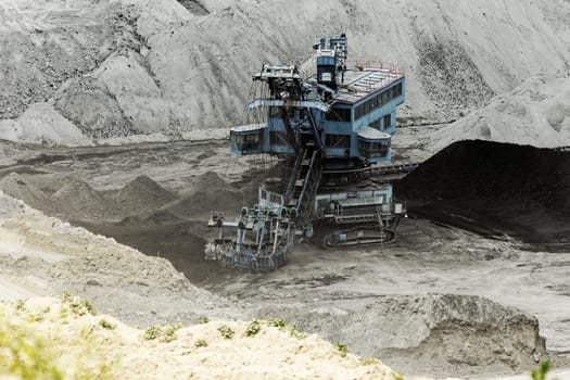 Coal mining in an open pit with huge industrial machine