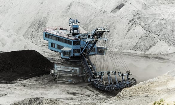 Coal mining in an open pit with huge industrial machine