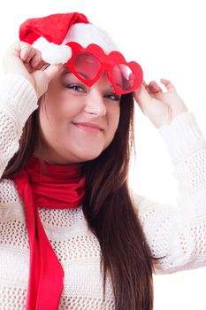 Smiling woman in Santa hat lifting heart-shaped glasses up isolated on white