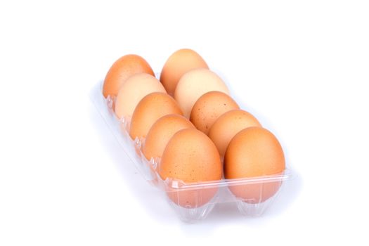 Ten eggs in a plastic transparent package on white background