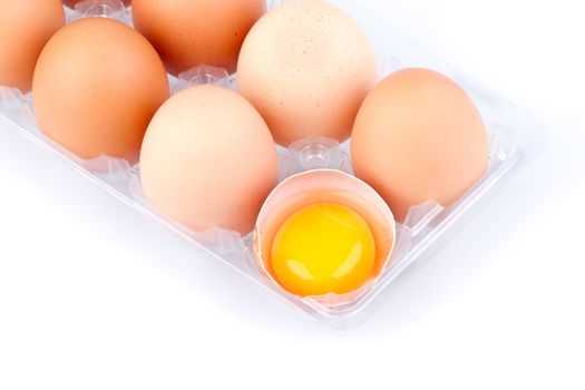 Eggs and yolk in a plastic transparent package on white background