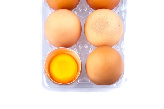 Eggs and yolk in a plastic transparent package on white background