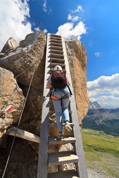 hiker on a big wooden ladder in Bepi Zac via ferrata, Trentino, Italy