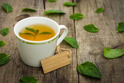 A cup of mint tea on wood textured background