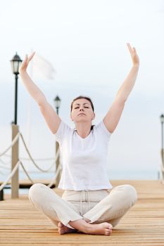 girl is engaged in gymnastics in the morning in the fresh air by the sea