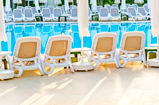 empty chairs stand around the pool at the hotel