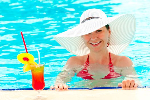 young girl in a white hat in the swimming pool