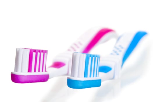 blue and pink toothbrushes lying on a white background