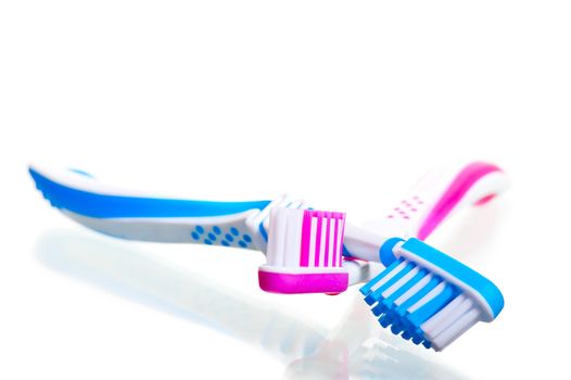 two toothbrushes crossed on a white background