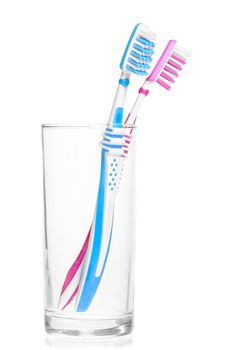 pair of new toothbrushes in a glass on a white background