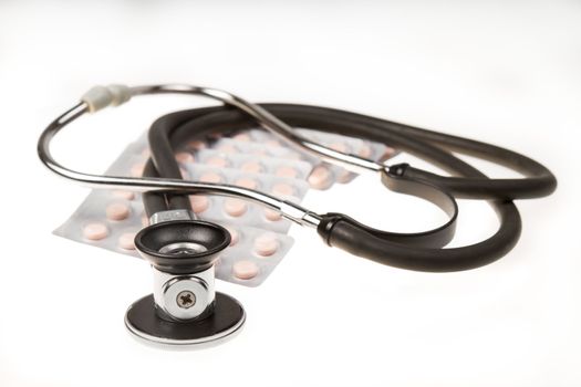 Stethoscope and tablets on isolated white background