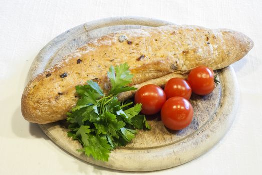 Homemade organic baguette bread with cherry tomatoes and parsley