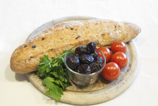 Homemade organic baguette bread with olives, cherry tomatoes and parsley