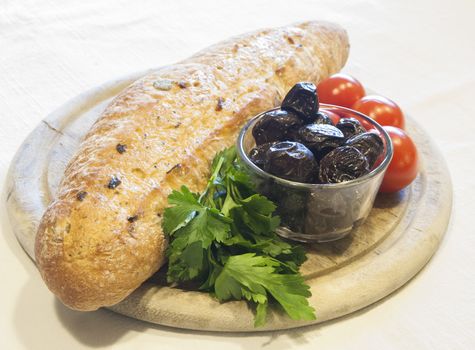 Homemade organic baguette bread with olives, cherry tomatoes and parsley