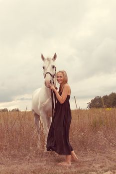 beautiful young woman with a  horse in the forest