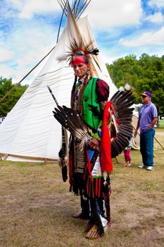 Whitesburg, GA - Sept. 29: Native American Indian warrior with weapons standing in front of Tipi at the McIntosh Fall Festival, Sept. 29 2013 in Whitesburg, GA.