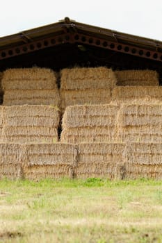 straw bales under the roof in the meadow