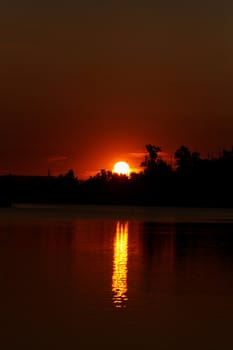 Colorful sunset over tranquil water surface.