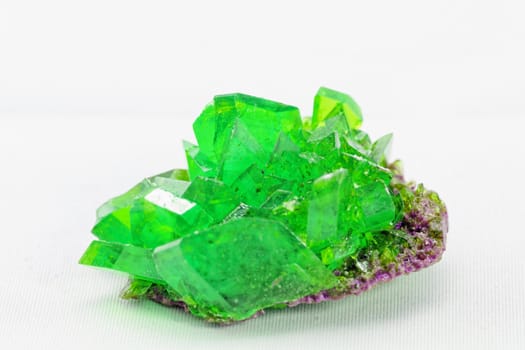 Close up picture about a crystal with emerald color on white background (green crystal)