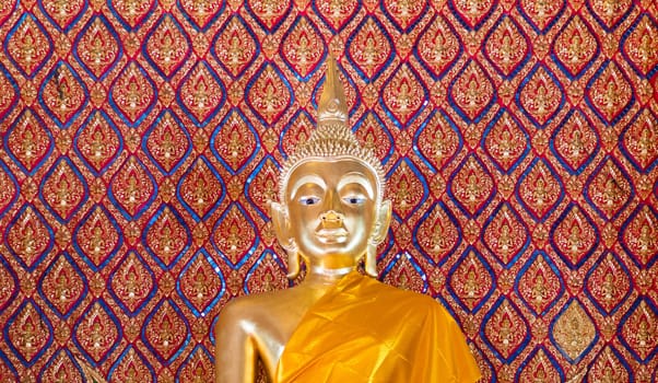 gold buddha statue in church with pattern of art thai in background