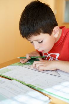 boy doing school homework from mathematics, geometry in workbook