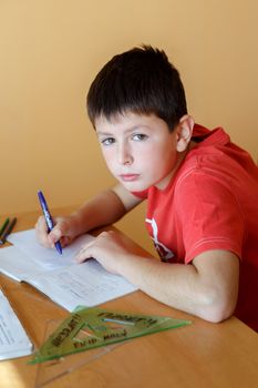 boy doing school homework from mathematics in workbook