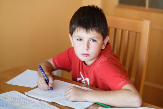 boy doing school homework from mathematics in workbook