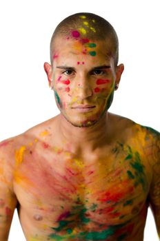 Handsome young man with skin all painted with colors and serious expression, looking in camera