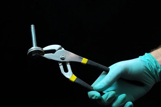 Pliers and a Hand on a Black Background