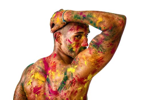 Attractive young man shirtless, skin painted all over with bright Honi colors, seen from the back with arm held up