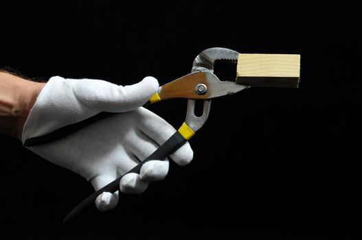 Pliers and a Hand on a Black Background