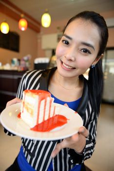 The beautiful smiling asian young woman with a cake