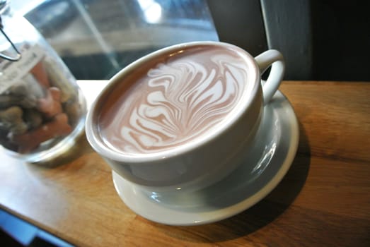 Tasty latte cup with a cream drawing.