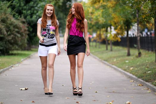 Happy two young women in autumn city