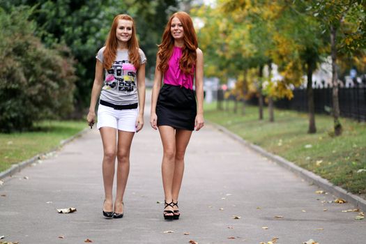 Happy two young women in autumn city