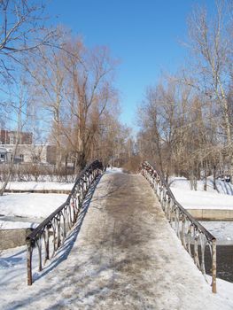 The bridge through the river in the winter 