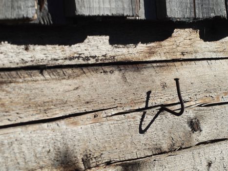 bent nail into a wooden wall